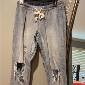 Draw string distressed jeans with holes in knees.